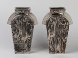 two vases sitting side by side on a white surface