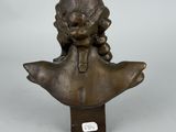 a bronze bust of a girl with a hat on her head