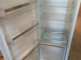 an empty refrigerator with its door open in a room