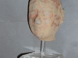 a clay head of a man on a clear stand