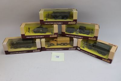 six boîtes contenant des trains miniatures, posées sur une surface blanche
