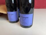 two bottles of wine sitting on a table next to each other