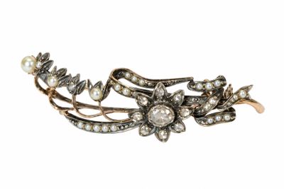 une photo en gros plan d'une broche ornée de perles