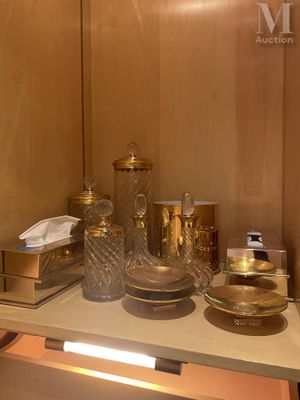 une salle de bains avec un lavabo, un miroir et de nombreux objets posés sur le plan de travail