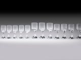 several empty wine glasses are lined up on a white surface