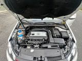 le moteur d'une voiture dont le capot est ouvert, garée dans la rue