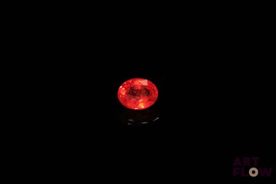 un diamant rouge dans l'obscurité, sur fond noir