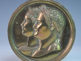 une pièce de bronze sur laquelle figurent une femme et un homme