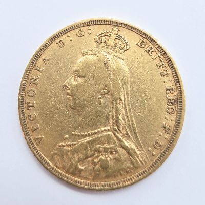 gros plan d'une pièce d'or sur une surface blanche