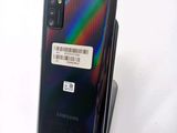 the back of a black samsung note 10 with a barcode sticker on it