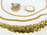 three pieces of jewelry sitting on top of a white surface