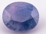 a close up of a blue sapphire stone on a white surface