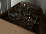 de nombreux verres à vin vides dans une boîte posée par terre