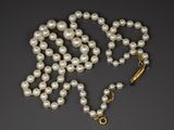 un gros plan d'un collier de perles sur fond noir