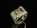 un gros plan d'une bague en argent sertie de diamants sur une surface noire