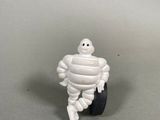 a small toy figurine of a man sitting on a tire