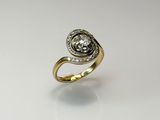 a close up of a gold and diamond ring on a white surface