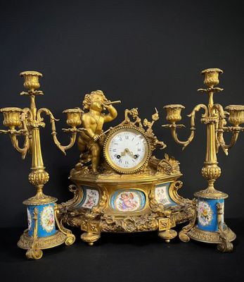 une horloge en or posée sur une table avec des bougies