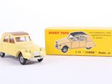 yellow toy car in front of a yellow box on a white surface