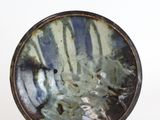 a plate that is sitting on a stand on a white surface