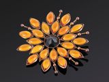 un gros plan d'une broche jaune posée sur une surface noire
