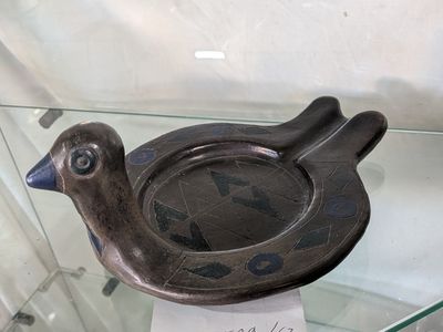 un cendrier en forme d'oiseau exposé dans une vitrine