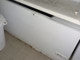 a white refrigerator and a white trash can in a small room