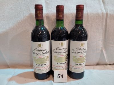 trois bouteilles de vin posées sur une nappe blanche