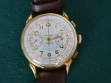 an image of a close up of a wrist watch on a green surface