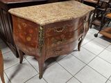 une commode ancienne avec un plateau en marbre, dans un magasin