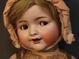 a close up of a doll with a hat on