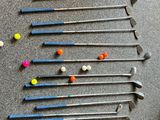 many golf clubs and balls laid out on the floor
