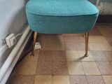 a small blue chair sitting next to a bed