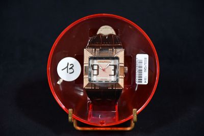 une petite assiette rouge sur laquelle est posée une montre