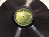 vinyl record with a green apple on it sitting on a table