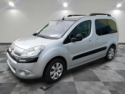 the small silver van is parked on a checkered tile floor