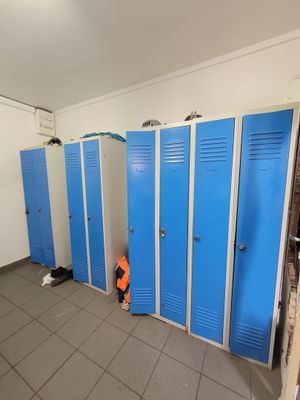 several blue lockers are lined up in a row in a bathroom
