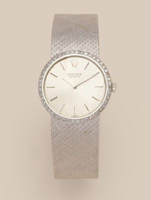 a lady ' s wrist watch with a white dial and a diamond bezel