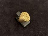 a picture of a gold signet ring on a black surface