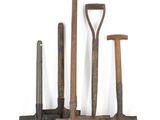 cinq types différents d'outils de jardinage posés sur une surface blanche