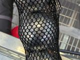 a person holding a netted bag full of fruit