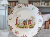a plate with a picture of people on it on a table