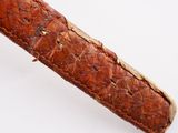 a close up of a leather pen case on a white surface