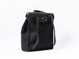 the small black bag is sitting on a white surface