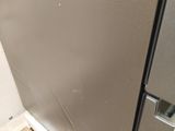a picture of a stainless steel refrigerator in the corner of a room