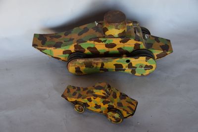 un char miniature et une petite voiture posés sur une table