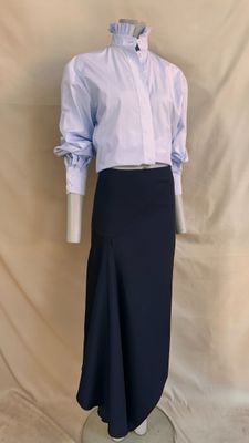 a mannequin wearing a skirt and a shirt on a mannequin stand
