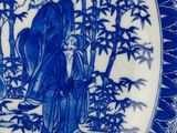 a blue and white plate with a picture of a man and a woman