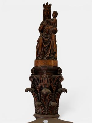 an antique carved wooden statue of a woman holding a child