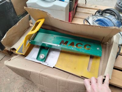 une boîte en carton contenant quelques outils, posée sur une palette